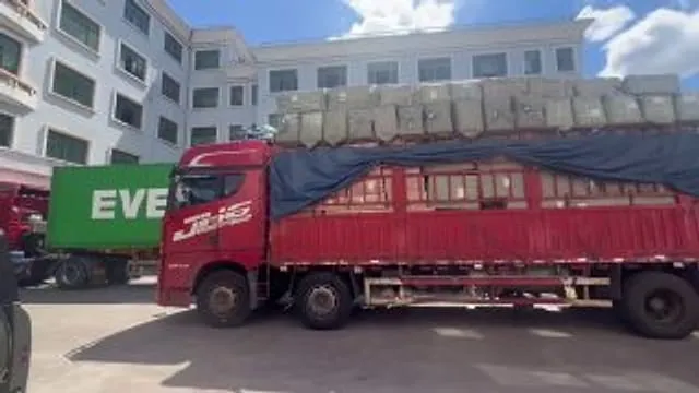 Грузовик с высоко загруженным сборным грузом у склада